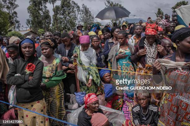 Displaced people wait for a food distribution and non-food items distributed by UNICEF to sustain them during this period of crisis in Munigi on...