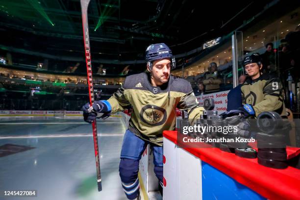 Dylan DeMelo of the Winnipeg Jets hits the ice for the pre-game warm up wearing a special military themed jersey for Canadian Armed Forces...