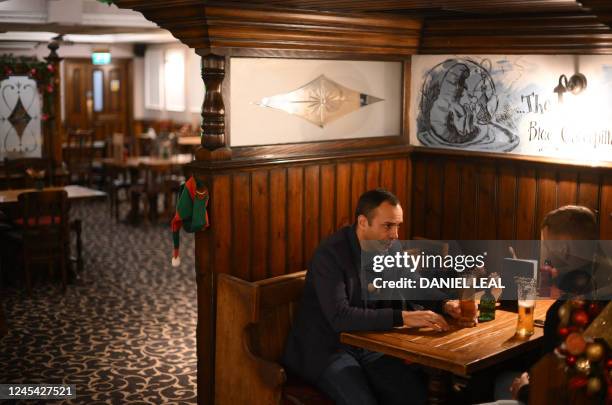 Festive elf's hats rest on the edge of a booth as customers enjoy drinks at the Mad Hatter pub and hotel, operated by Fuller's, in London on November...