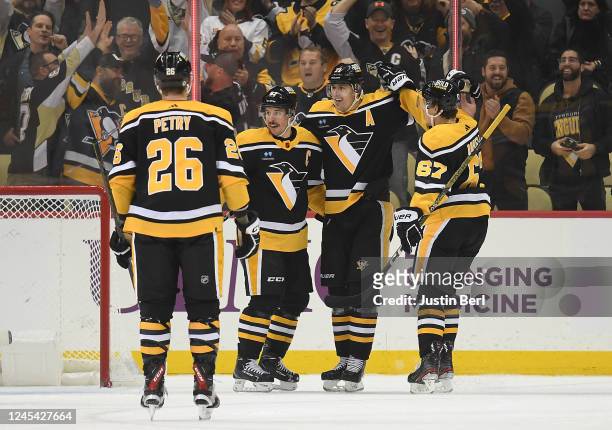Sidney Crosby of the Pittsburgh Penguins celebrates with Evgeni Malkin and Rickard Rakell after scoring his second goal in the second period during...