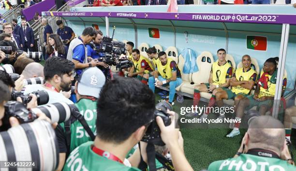 Photographers aim their cameras at Portugal star Cristiano Ronaldo as he starts on the bench in a World Cup round of 16 football match against...
