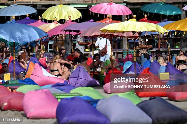 Foreign tourists enjoy their holiday on a beach in Seminyak, Badung regency on Indonesia resort island of Bali on December 7, 2022.