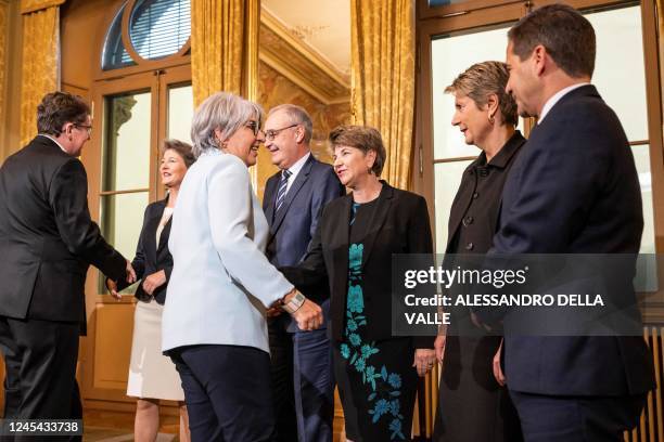 The newly elected members of the Federal Council, Albert Rosti , and Elisabeth Baume-Schneider, , are greeted by their new colleagues, , Chancellor...