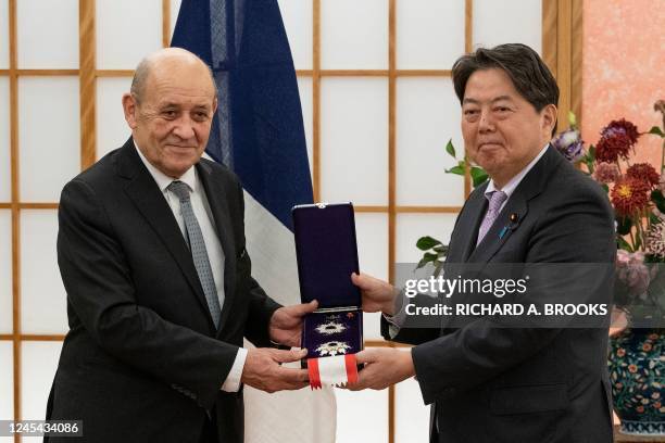 France's former foreign and defence minister Jean-Yves Le Drian poses with Japan's Foreign Minister Yoshimasa Hayashi during a presentation ceremony...