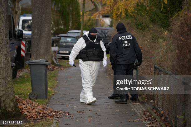 Policemen are seen in a street during a raid on December 7, 2022 in Berlin that is part of nationwide early morning raids against members of a...