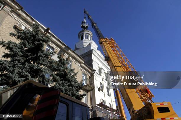 Workers install the 90kg tryzub instead of the five-pointed star, one of the Soviet symbols, atop the spire on the roof of a building on the Day of...