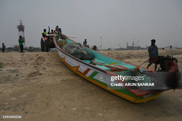 Fishermen pull their boat out of the Indian Ocean at Marina beach in Chennai on December 7 during preparations ahead of Cyclone Mandous forecasted...