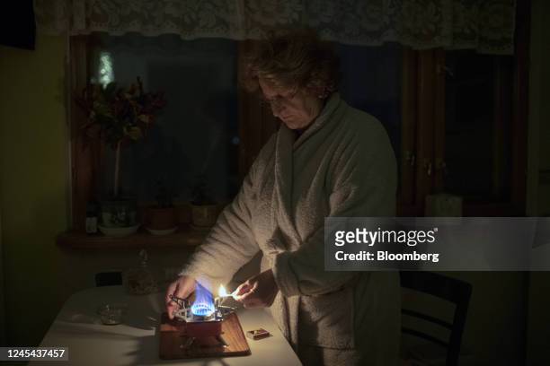 Resident lights a camping stove at home during a power outage in Kyiv, Ukraine, on Tuesday, Dec. 6, 2022. Ukrainians have been no strangers to...
