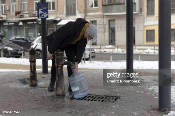 Resident collects water from a pump in Kyiv, Ukraine, on Tuesday, Dec. 6, 2022. Ukrainians have been no strangers to hardship over the past century,...