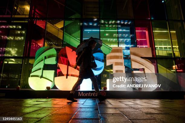 Person walks by the lit up sign during the United Nations Biodiversity Conference in Montreal on December 7, 2022.