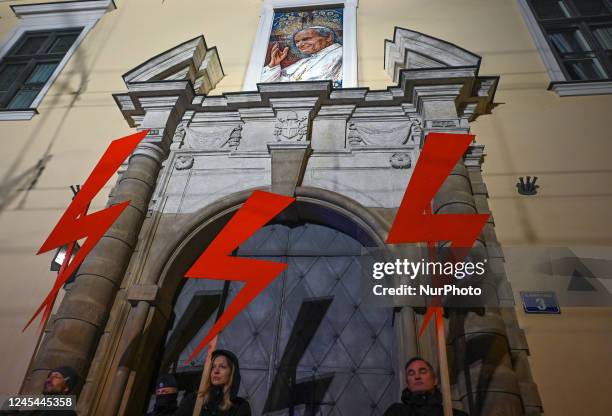 Activists hold three red lightning bolts, the main symbol of the pro-choice movement, outside the 'Papal Window' of of the Bishop's Palace during the...