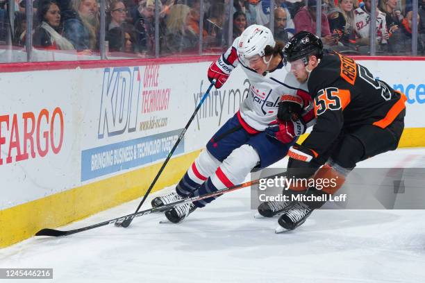 Sonny Milano of the Washington Capitals battles with Rasmus Ristolainen of the Philadelphia Flyers for the puck in the first period at the Wells...