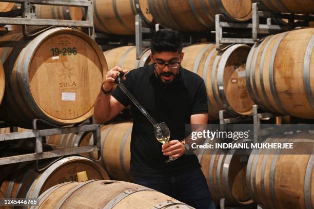 In this photograph taken on October 19 Karan Vasani, chief winemaker of Sula Vineyards, checks a batch of wine at the winery of Sula Vineyards in...