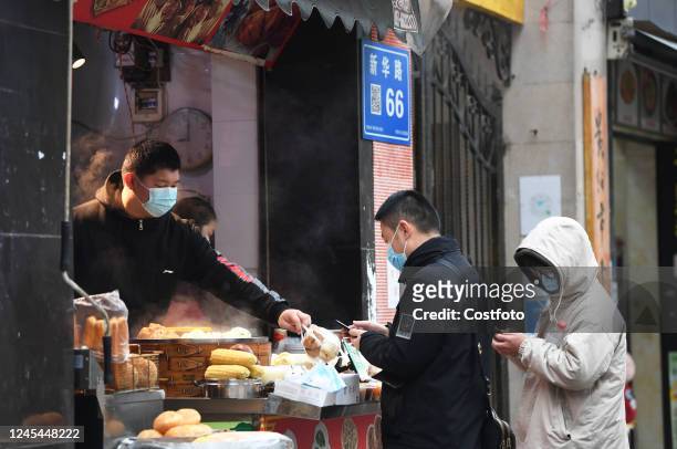 People wear masks to buy breakfast in Guiyang, Guizhou province, China, Dec 8, 2022.