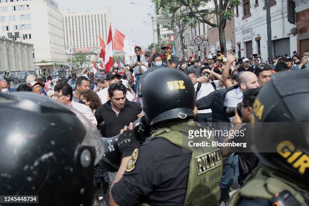 Riot police officers stand guard as demonstrators protest against Pedro Castillo, Peru's former president, following his impeachment and arrest, near...