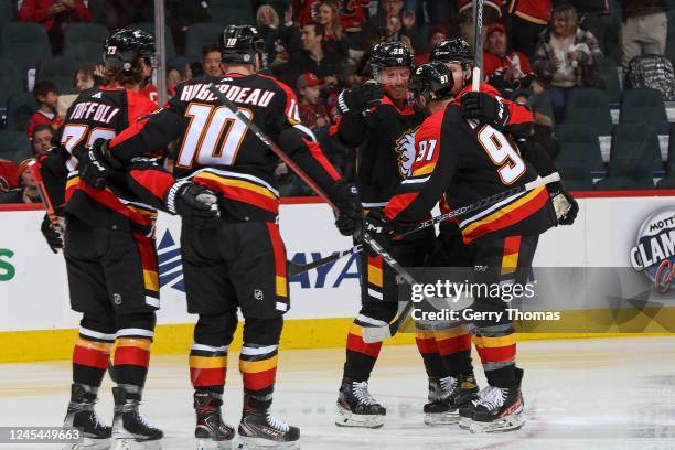 Nazem Kadri of the Calgary Flames celebrates with teammates after a goal against the Minnesota Wild at Scotiabank Saddledome on December 7, 2022 in...