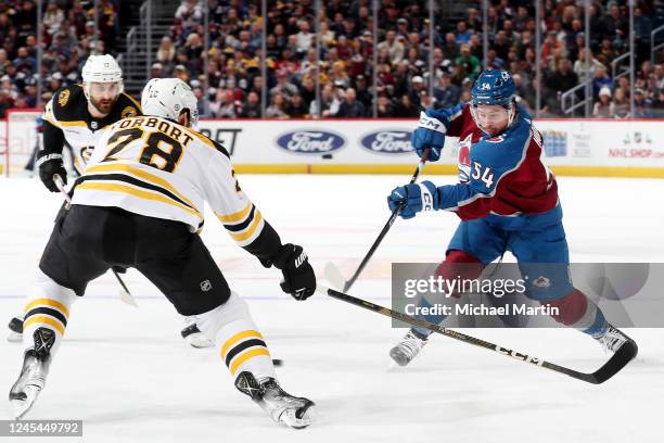 Charles Hudon of the Colorado Avalanche takes a shot against Derek Forbort of the Boston Bruins at Ball Arena on December 7, 2022 in Denver, Colorado.