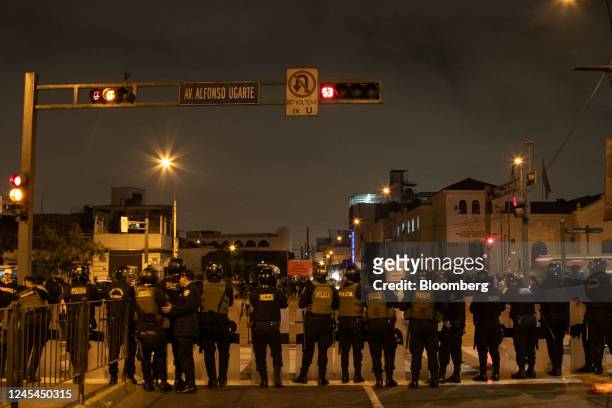 Police officers stand guard on Alfonso Ugarte Avenida, near the Lima Prefecture where Pedro Castillo, Peru's former president, is held following his...