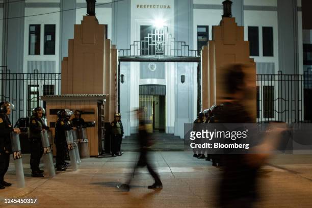 Police officers stand guard at the Lima Prefecture where Pedro Castillo, Peru's former president, is held following his impeachment and arrest in...