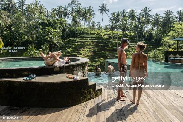 Foreign tourists use a swimming pool with a rice terrace in the background on December 8, 2022 in Ubud, Bali, Indonesia. Indonesia's parliament voted...