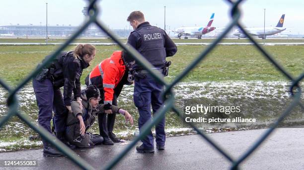 December 2022, Bavaria, München-Flughafen: Two officers of the Federal Police and a security employee stand with a seized bolt cutter at a fence at...