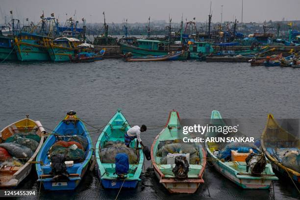 Fisherman moors his boat amid high tide as dark clouds loom over the Kasimedu fishing harbor in Chennai on December 8 ahead of Cyclone Mandous...