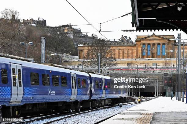 ScotRail trains in the snow at Waverley station, with Edinburgh Castle in the background, as rail unions plan strikes over the Chistmas period, on...