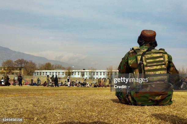 Taliban security personnel keeps watch ahead of the court flogging of women and men at a football stadium in Charikar city of Parwan province on...