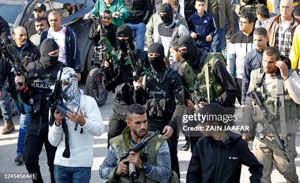 Graphic content / Palestinian gunmen take part in the funeral procession of three Palestinians killed by Israeli forces in a raid in the West Bank...