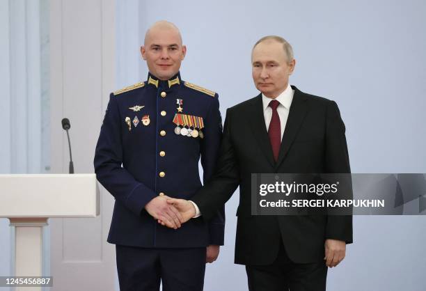 Russian President Vladimir Putin shakes hands with Major Boris Dudko , deputy commander of the 124th tank squad of the 76th air assault division of...