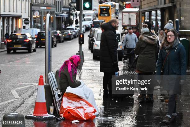 Young woman begs outside Waverley station in wintry weather, on December 8, 2022 in Edinburgh, Scotland.