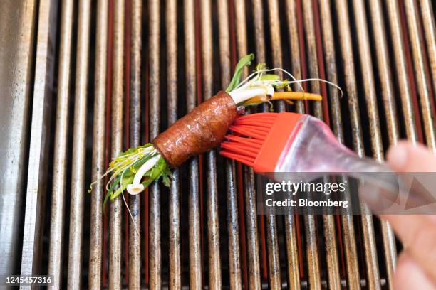 Chef brushes cultivated thin-cut steak rolled around vegetables with oil as it is grilled in the Aleph Farms Ltd. Development kitchen in Rehovot,...