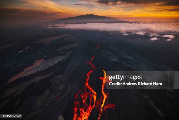 In an aerial view, lava fissures flow downslope from the north flank of Mauna Loa Volcano on December 7, 2022 in Hilo, Hawaii. For the first time in...