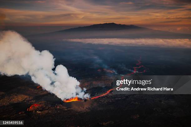 In an aerial view, lava fissures flow downslope from the north flank of Mauna Loa Volcano on December 7, 2022 in Hilo, Hawaii. For the first time in...