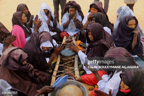 Tuareg woman play the tende, a drum made out of a mortar, in Iferouane on December 2, 2022 during the Festival de l'Aïr, a celebration of the culture...