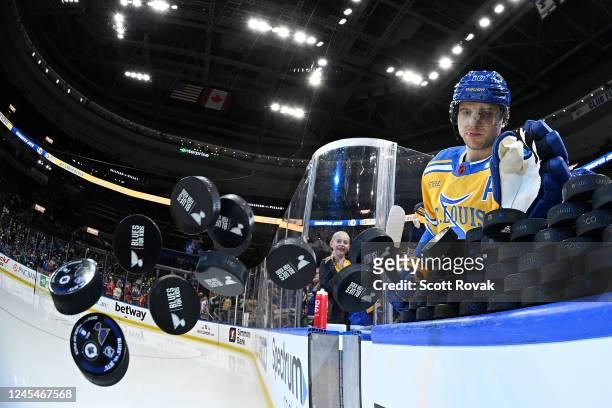 Brayden Schenn of the St. Louis Blues knocks the pucks onto the ice for warmups against the Winnipeg Jets at the Enterprise Center on December 8,...