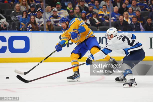 Jordan Kyrou of the St. Louis Blues shoots the puck against Dylan DeMelo of the Winnipeg Jets in the first period at Enterprise Center on December 8,...