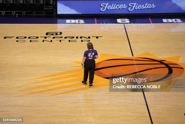 Kate Frese, the team photographer for the WNBA's Phoenix Mercury, wears a Brittney Griner t-shirt as she walks across the basketball court at the...