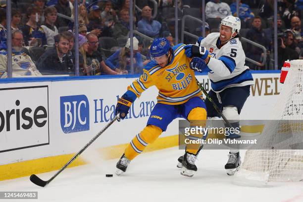 Brandon Saad of the St. Louis Blues fights Brenden Dillon of the Winnipeg Jets for control of the puck in the third period at Enterprise Center on...