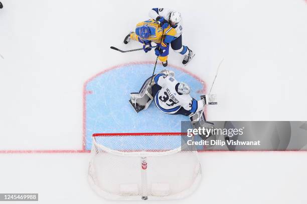 Brenden Dillon and Connor Hellebuyck of the Winnipeg Jets defend the goal against Josh Leivo of the St. Louis Blues in the second period at...