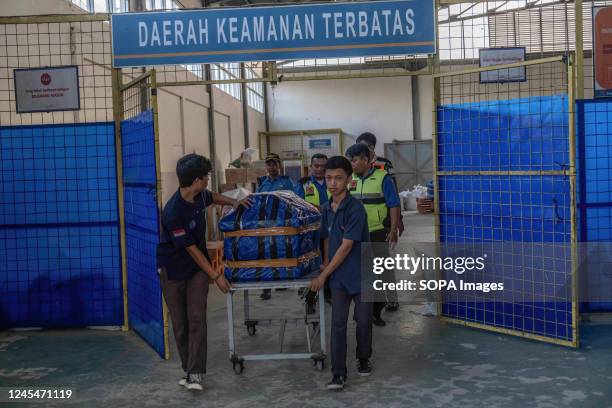 Officers remove the bodies of the victims of the KKB shooting from the cargo terminal at Halu Oleo airport. On December 5, three motorcycle taxi...