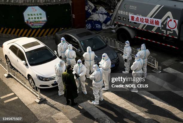 Workers wearing personal protective equipment are seen on a steet near a residential community that just opened after a lockdown due to Covid-19...