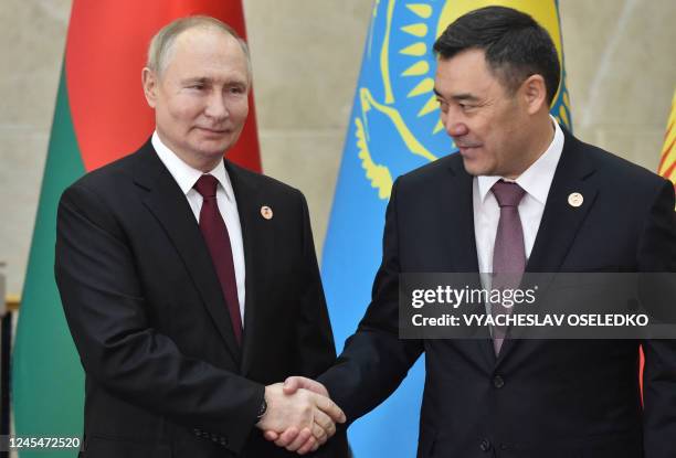 Russia's President Vladimir Putin shakes hands with Kyrgyzstan's President Sadyr Japarov before attending the Supreme Eurasian Economic Council...