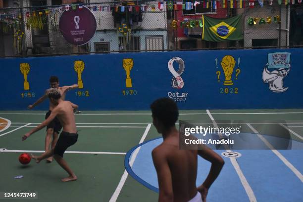 Children play soccer at a field in the Morro favela of Rio de Janeiro, Brazil, on December 08 , 2022. Teenagers play soccer and exchange game cards...