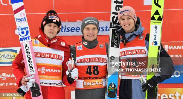 Second placed Poland's Dawid Kubacki, winner Slovenia's Anze Lanisek and third placed Germany's Karl Geiger celebrate on the podium after the FIS ski...