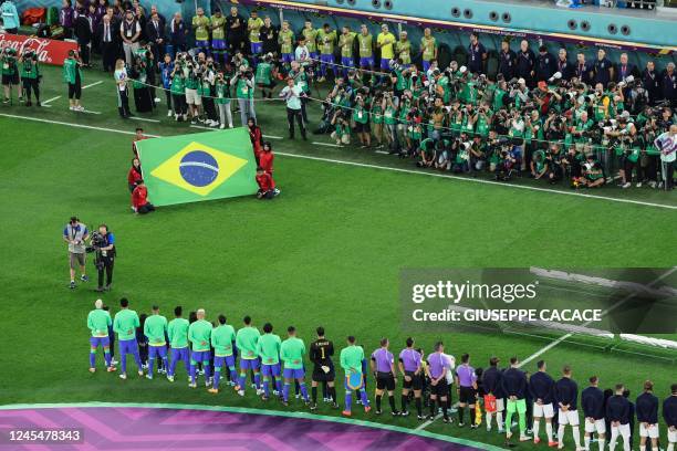 Brazil's and Croatia's team players stand during the national anthem before the start of the Qatar 2022 World Cup quarter-final football match...