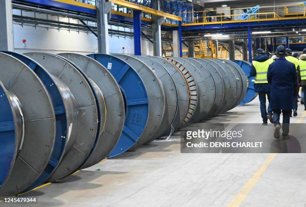 An employees of the Alcatel Submarine Networks site checks reels of fiber optic cable shielding wire, in Calais, northern France, on December 9,...