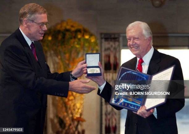 Former US president Jimmy Carter receives the 2002 Nobel Peace Prize from the chairman of the Norwegian Nobel Committee Gunnar Berge during a...