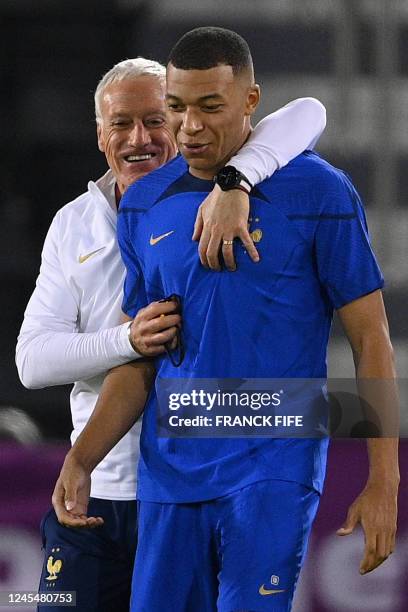 France's coach Didier Deschamps jokes with France's forward Kylian Mbappe during a training session at Al Sadd SC Stadium in Doha, on December 9 on...