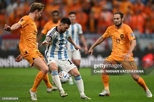 Argentina's forward Lionel Messi is marked by Netherlands' midfielder Frenkie De Jong and Netherlands' defender Daley Blind during the Qatar 2022...